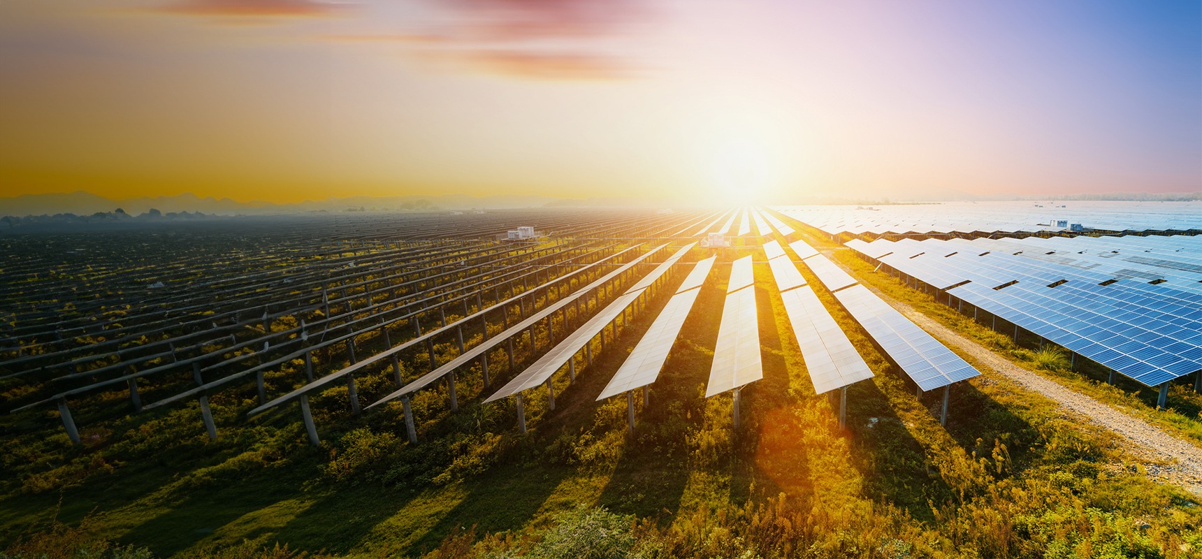 Solarpark auf freiem Feld bei Sonnenaufgang